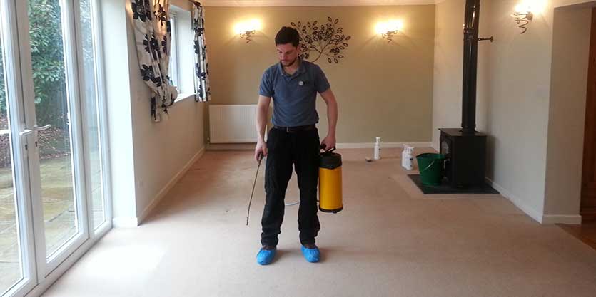 A man holding a spray bottle and a hose.