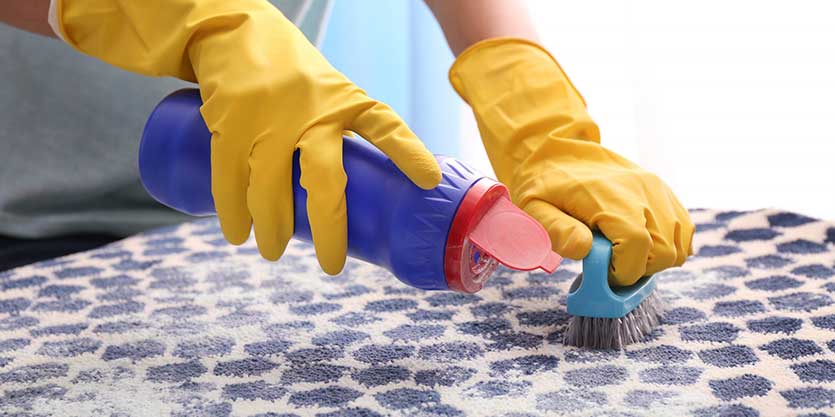 A person in yellow gloves cleaning the floor.